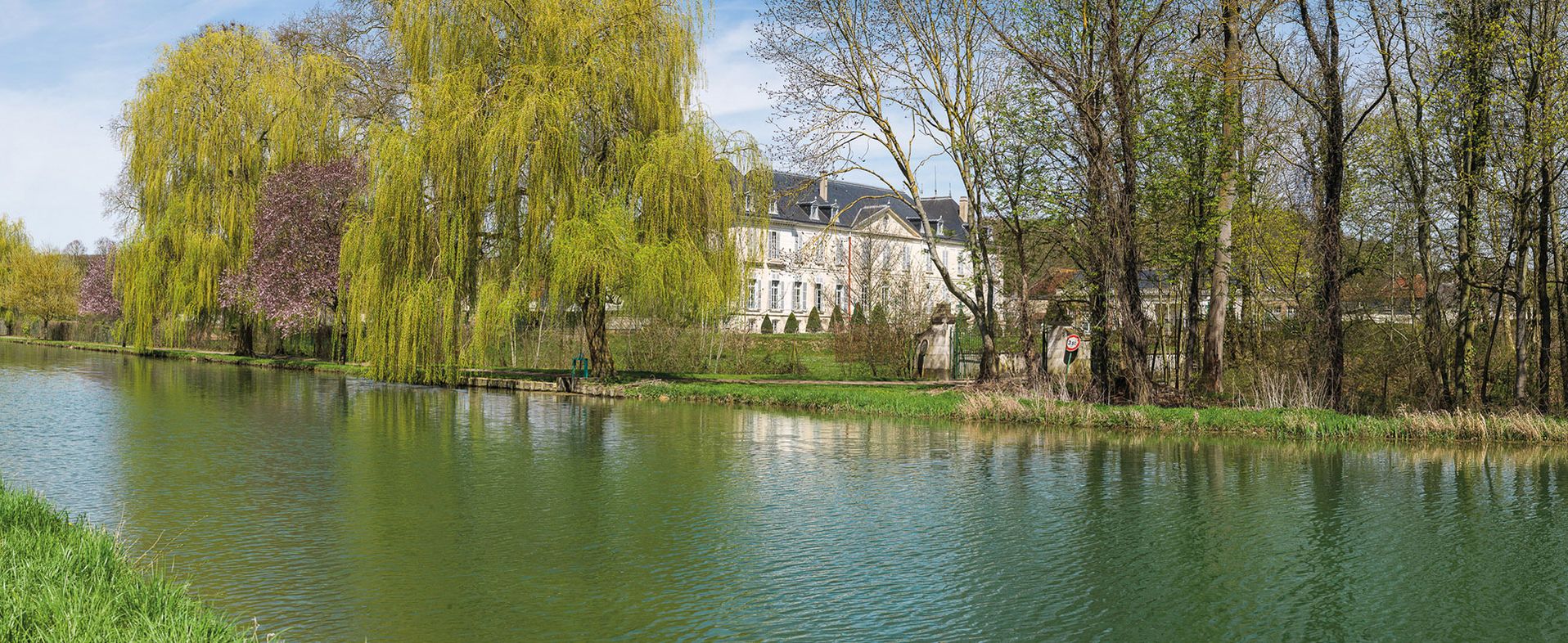 Le château de Cheney vu de la rive gauche. On aperçoit la vanne d'une rigole du parc du château. Bief 98  du versant Yonne, Cheney.