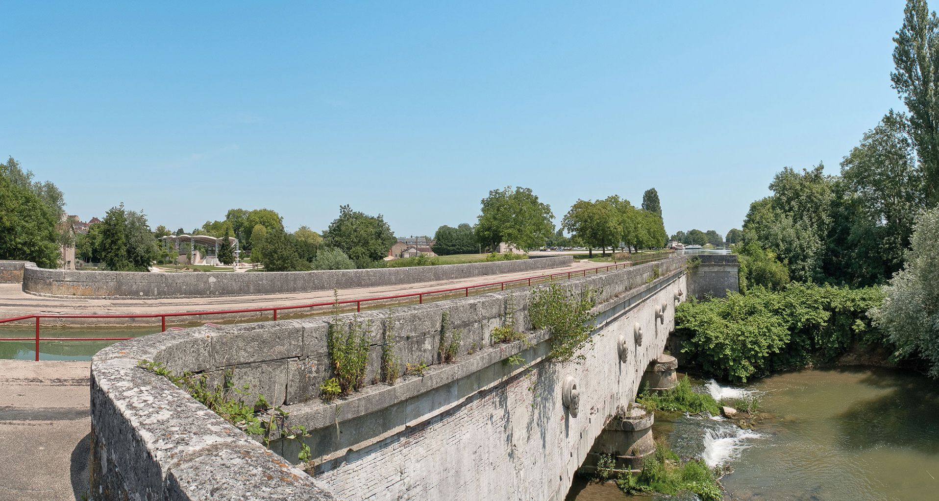 Pont-canal de Saint-Florentin vu du site d’écluse 108 du versant Yonne à Saint-Florentin. Remarquez les décors sculptés sur le tablier du pont qui enjambe l’Armance.