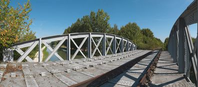 Pont de la ligne de chemin de fer Chalon-Gray, prolongement de la ligne Auxonne-Gray ouverte le 10 novembre 1856. Il était en cours de construction dans les années 1880 car un pont provisoire fut aménagé en 1882 en attendant la pose du tablier du pont définitif projeté. Aujourd’hui désaffecté. Bief 76 du versant Saône à Saint-Usage.