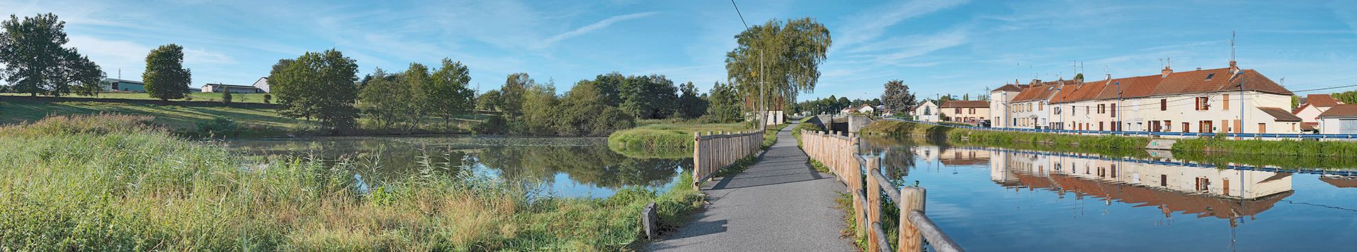 Canal du Centre&nbsp;: le bief 03 pris de l'aval de la rive droite à Ecuisses. Le réservoir de dépôt à gauche, le déversoir vers le canal sur le chemin de halage, la maison éclusière 02 et le site d'écluse 02. Deux petits lavoirs dans la rive gauche. Alignements de maisons le long du chemin de halage devenu route départementale.