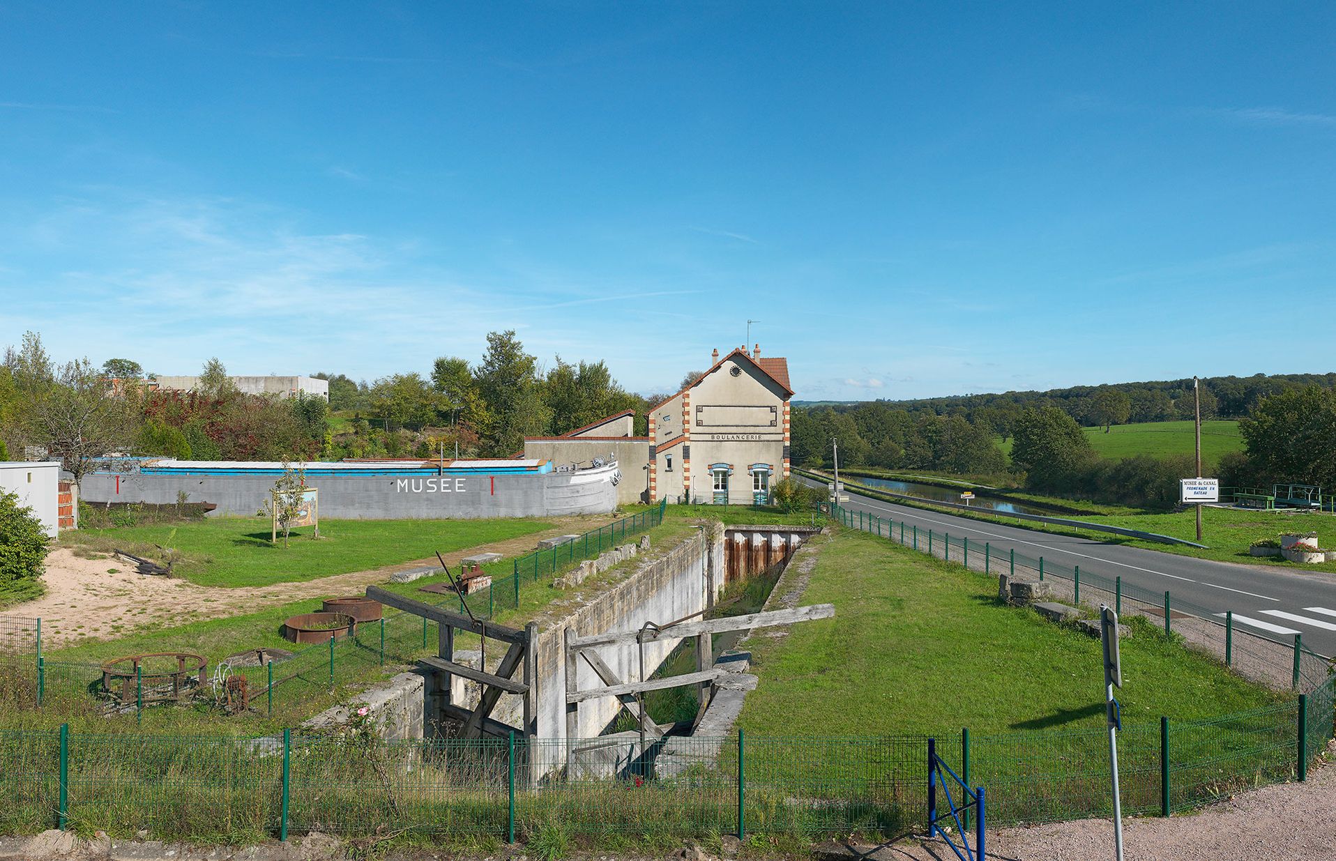 Canal du Centre à Écuisses. De gauche à droite&nbsp;: la péniche-salle d'exposition du Musée du canal, la boulangerie de la Cité Perrusson dans l'axe de l'ancien tracé du canal. C’est l’ancien site d’écluse IX du versant Méditerranée.