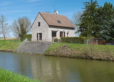 Ancienne maison éclusière du site d’écluse XXXIV, aujourd’hui située en aval du site d’écluse 25 du versant Méditerranée, à Rully. On peut encore voir le perré en moellon sur le talus du canal.