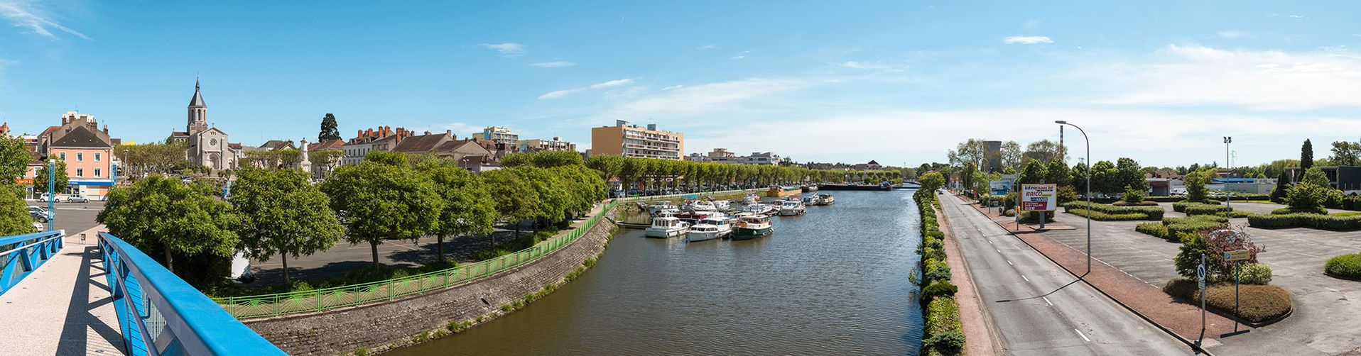 Panorama de la ville de Montceau-les-Mines pris depuis la passerelle, avec de gauche à droite&nbsp;: l'église, le port et au fond, la centrale électrique de Lucy.