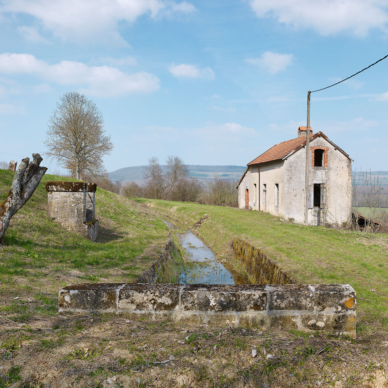 La maison de garde d’Eguilly avec au premier-plan, la rigole de Thorey en souterrain et à gauche, le puits de la maison.