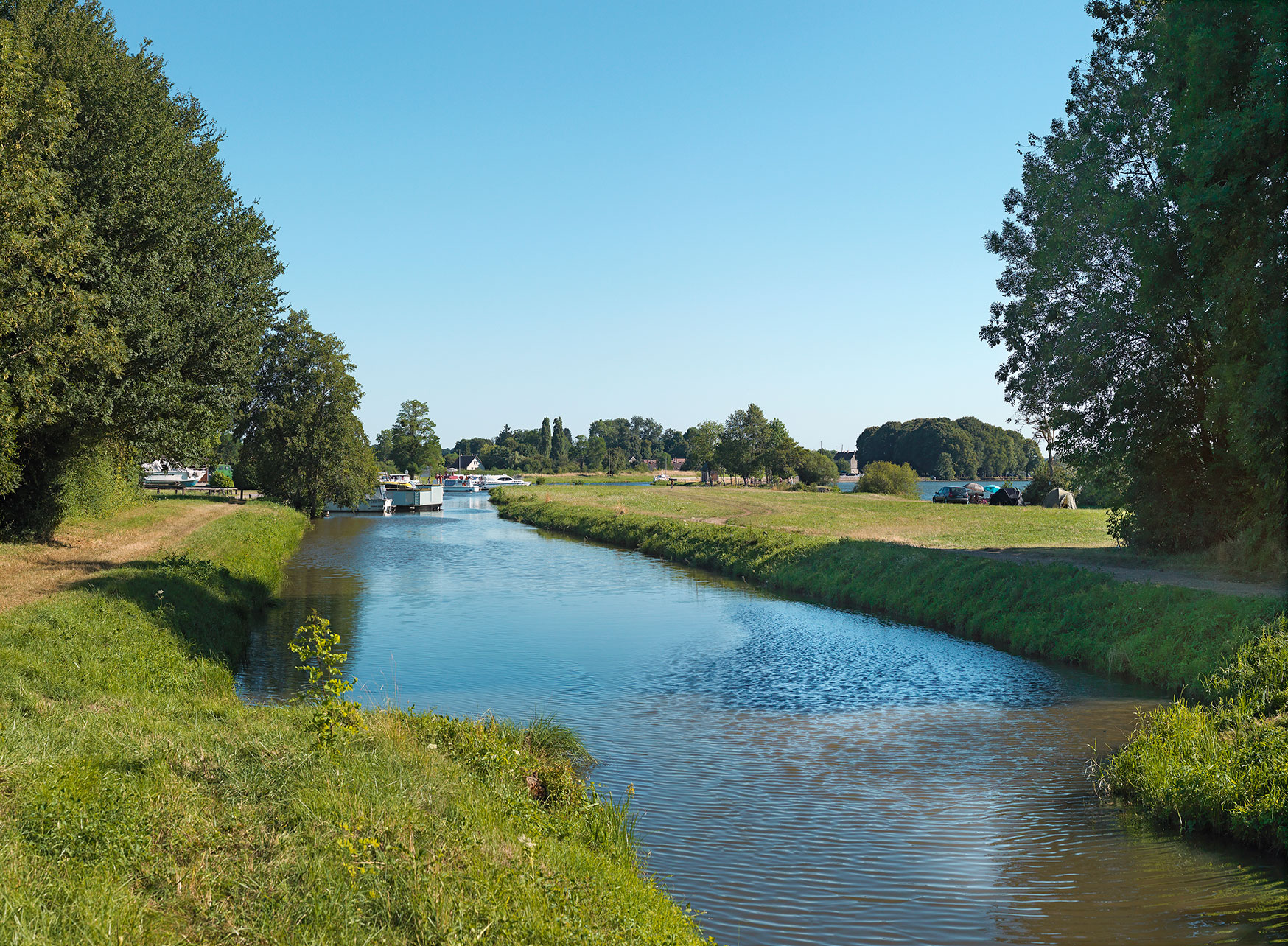 La rigole de Vaux longeant l’étang de Vaux, sur la droite. Au fond, le port des Poujeats. Bief de partage à La Collancelle.